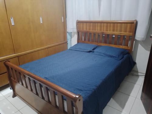 阿帕雷西达CANTINHO VOLTE SEMPRE的一间卧室配有一张带蓝色床单的木床。