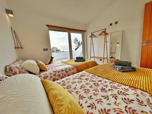 阿尔热祖尔Olive Tree Sunset View - V3 luxo vista mar的酒店客房设有两张床和窗户。