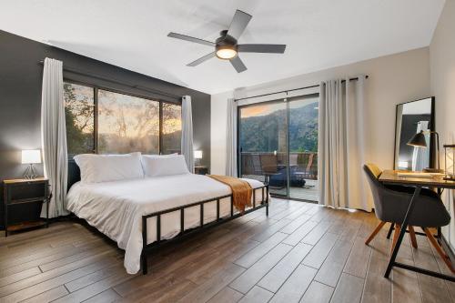 三河城Secluded Mountain Top Home Minutes to Sequoias & Kings Canyon的一间卧室配有一张带吊扇的床和一张书桌。