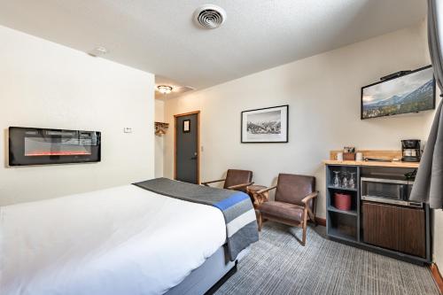 莱文沃思Hotel Leavenworth的配有一张床和一把椅子的酒店客房