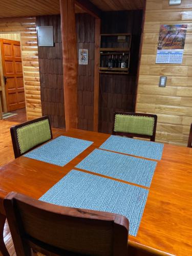 蒙特港Hostería Lenca的餐桌、两把椅子和一张木桌