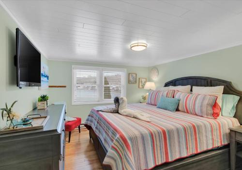 East HamptonSunset Cove的一间卧室配有一张床和一台平面电视