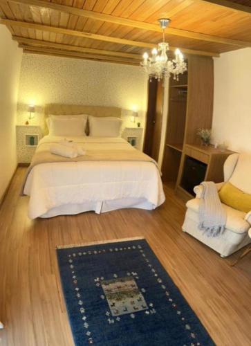 多明戈斯马丁斯Pousada Dulce Ville的一间卧室配有一张大床和一个吊灯。