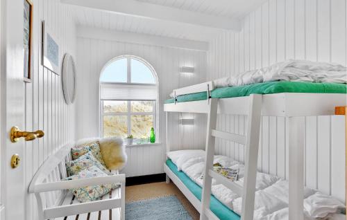 灵克宾3 Bedroom Beautiful Home In Ringkbing的一间卧室设有两张双层床和一扇窗户。