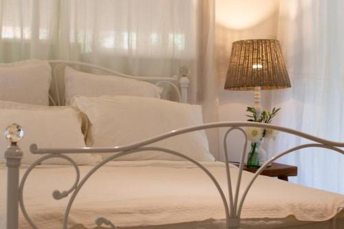 拜伦湾The Little House的一间卧室配有一张带灯和白色枕头的床