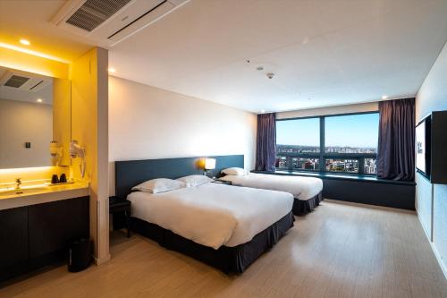 济州市济州贝斯特韦斯特酒店的酒店客房设有两张床和大窗户。