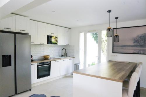 韦利济·维拉库布莱EXIGEHOME-Maison de standing-3 appartements-30 minutes de Paris的厨房配有白色橱柜和木制台面