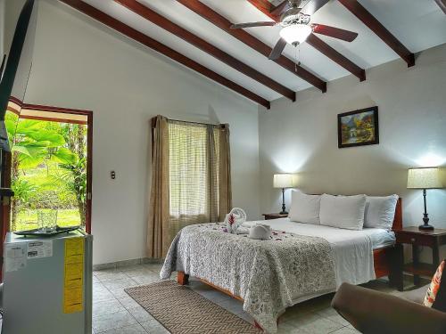 福尔图纳Loma Real Hot Springs Bed & Breakfast的一间卧室配有一张床和吊扇