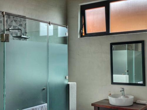 马萨米特拉Chalet 08的带淋浴、盥洗盆和镜子的浴室