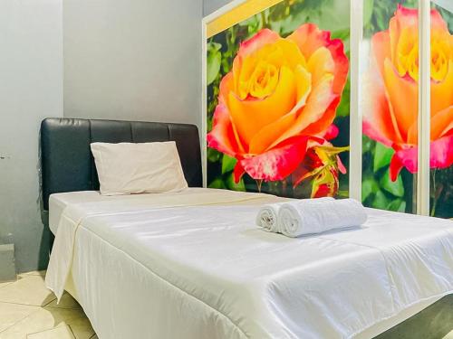 泗水Monalisa Homestay Mitra RedDoorz的一张白色的床,上面有两条毛巾