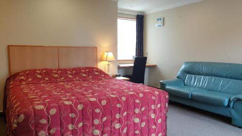 但尼丁莫莱97汽车旅馆的酒店客房,配有床和蓝色的沙发