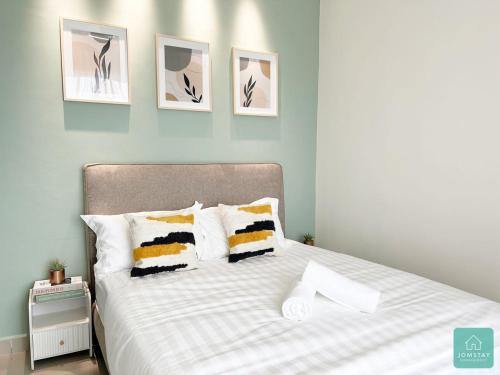 怡保JOMSTAY Majestic Ipoh Suites的卧室配有一张四幅画的墙壁床。