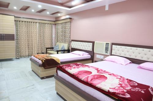 HaldiaSTAYMAKER Hotel Suraj - Only Indian Citizens Allowed的一间卧室,配有两张床