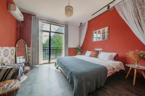 阳朔阳朔静苑客栈的卧室设有红色的墙壁、一张床和窗户