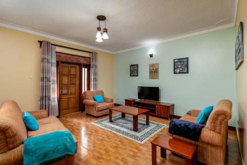 恩德培Victoria Breeze Suites, Entebbe的客厅配有两张沙发和一台电视机