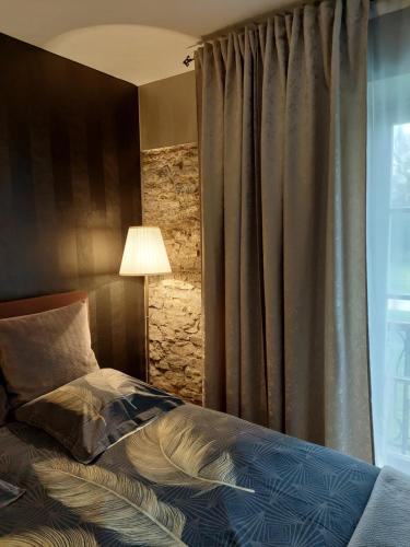 列日La chambre et le studio du château du golf de Bernalmont的一间卧室配有一张带灯和窗户的床