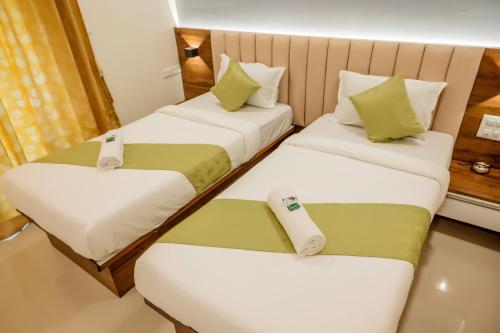 门格洛尔Hotel Heraa International的酒店客房带两张床和两个座位