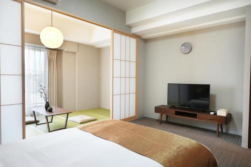 大阪川House道頓堀的一间卧室配有一张床和一台平面电视