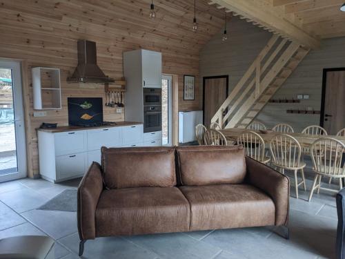 巴斯托涅Cosy chalet in nature的客厅设有厨房,配有棕色沙发