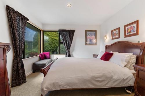 皇后镇Charming house with lovely views的一间卧室设有一张大床和一个窗户。