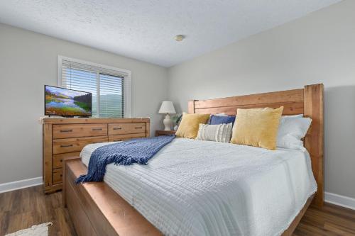 加特林堡Deer Ridge Mountain Resort A201的一间卧室配有一张大床和木制床头板