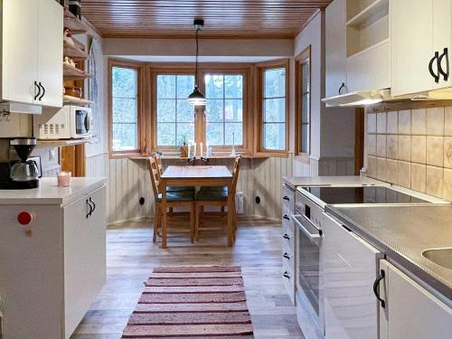 英斯约Holiday home YNGSJÖ III的厨房配有白色橱柜和桌子