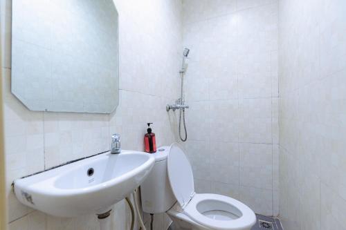 巴淡岛中心邦加拉亚街红门旅馆的一间带水槽、卫生间和镜子的浴室