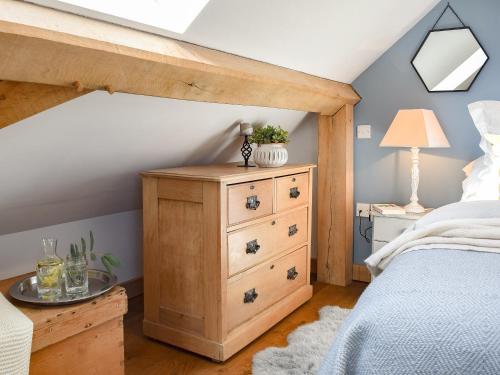 BensonShepherds Loft的一间卧室配有一张带木制梳妆台的床和一张床铺。