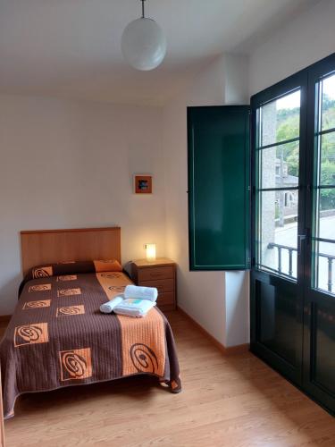 萨莫斯Hospedería Externa del Monasterio的一间卧室设有一张床和一个大窗户