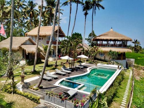 海神庙Coco Verde Bali Resort的一个带游泳池和棕榈树的度假村