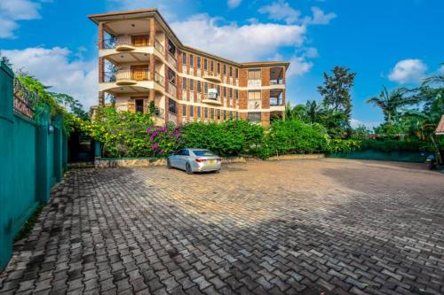 恩德培Victoria Breeze Suites, Entebbe的停在大楼前的汽车