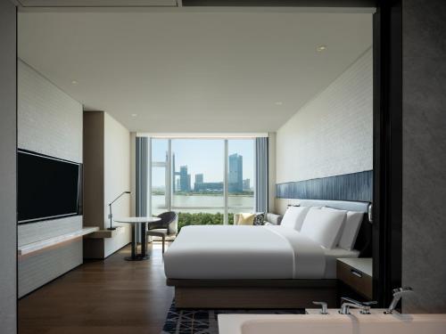 广州Guangzhou Marriott Hotel Nansha的酒店客房设有一张大床和一台电视。