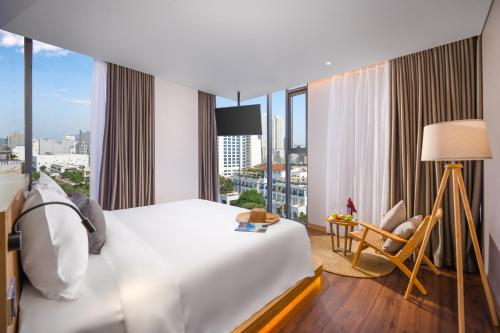 岘港Estrella Boutique Hotel的酒店客房设有一张床和一个大窗户