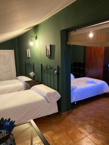 洛斯帕拉西奥西维利亚夫兰卡Villa Marina的绿墙客房内的两张床