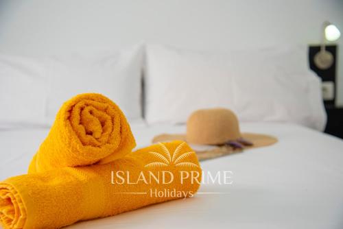 圣米格尔德阿沃纳Seaviews 2x Bedroom Apartment in Sand Club Complex的铺在床上的带帽子的滚动毛巾