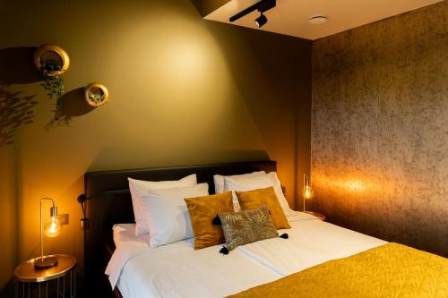 LangenboomBed en breakfast Suite 8的一间卧室配有带白色床单和黄色枕头的床。