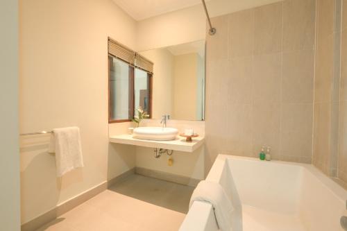 乌布Artini Bisma Ubud Hotel的带浴缸、水槽和浴缸的浴室