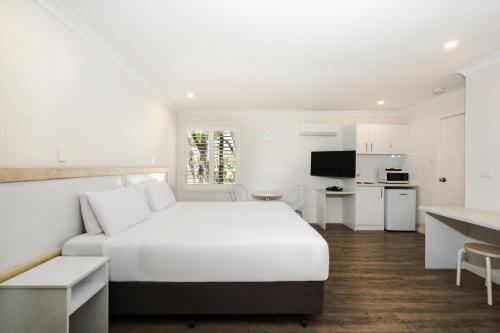巴瑟尔顿巴瑟尔顿乔格拉菲湾景度假酒店的一间白色卧室,配有床和厨房