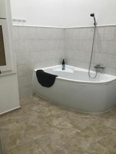 布达佩斯泽内斯豪斯公寓的带淋浴的浴室配有白色浴缸。