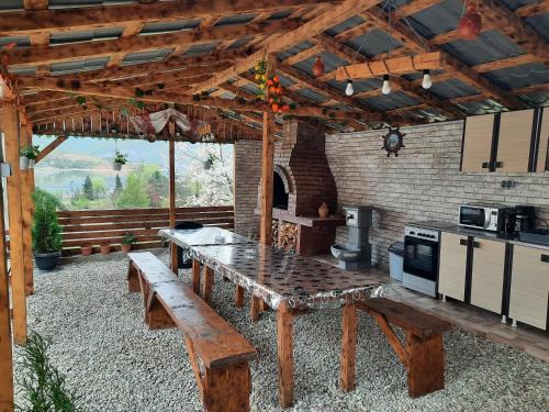 埃尔埃尼塔Casa Claudiu的一个带木桌的庭院和一间厨房