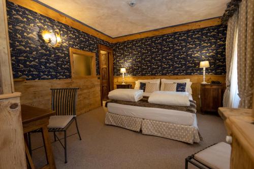 布勒伊-切尔维尼亚布卡奈维酒店的一间设有两张床的卧室,位于蓝色壁纸的房间