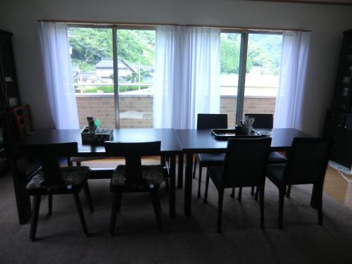 Niiペンション石田的一张餐桌和椅子,设有大窗户