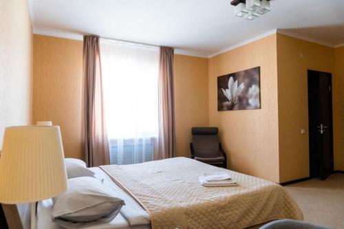 AksayComfort Hotel的一间卧室配有一张带灯和窗户的床