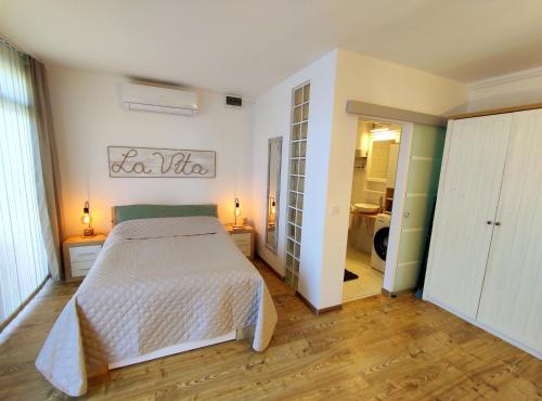 巴拉顿菲赖德LA VITA APARTMAN的一间带白色床的卧室和一间浴室