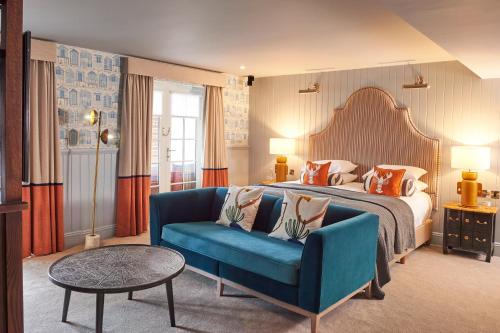 浦耳普尔酒酒店的酒店客房,配有床和蓝色的沙发