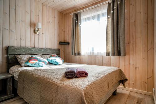 艾纳日Jūras dzintars的一间卧室配有一张床,上面有两条毛巾