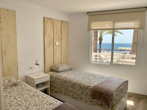 阿瓜杜尔塞Apartment Paseo的一间卧室设有两张床和一个海滩窗口
