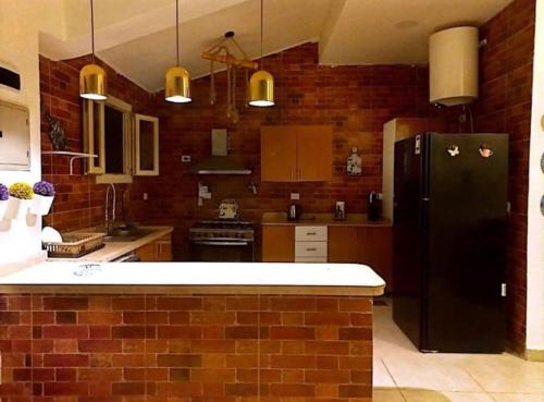 西迪基里尔Villa amoun的厨房配有黑色冰箱和砖墙