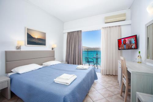 伊罗达Aristea Hotel的配有一张床、一张桌子和一张桌子的酒店客房