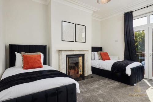 海丁利Stunning 5Bed All En-suite Headingley Home的带壁炉的客房内的两张床
